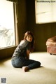 A woman sitting on the floor in front of a window.