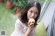 A woman sitting on a couch holding an apple.