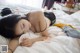 A woman laying on top of a bed next to a stuffed animal.