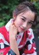 A woman in a red and white kimono posing for a picture.