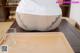 A person sitting on a table with a glass of water.