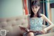A woman sitting on a couch reading a book.